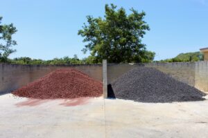 Image of red and black lava rocks piled at the stone yard side by side