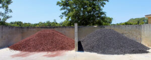 Image of red and black lava rocks piled side by side at the Rock Solid stone yard.